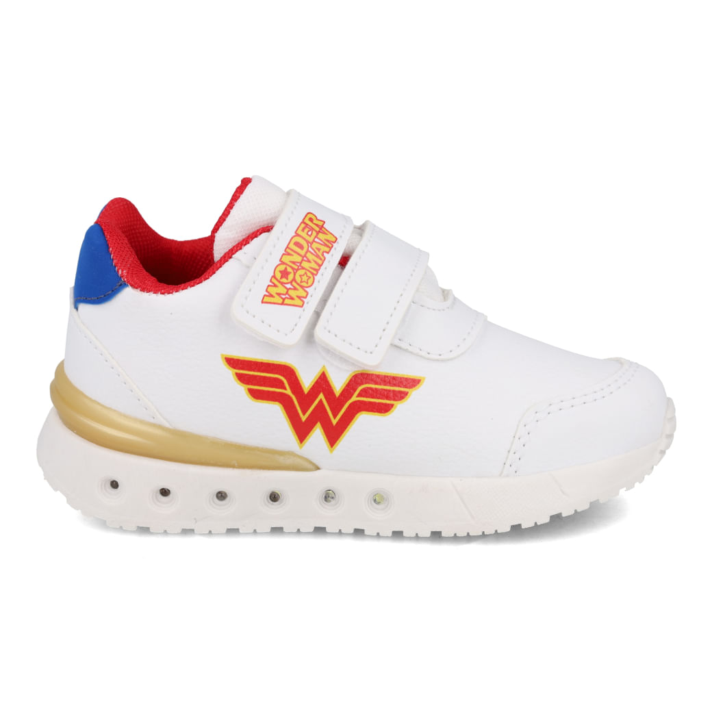 Tênis infantil feminino branco com estampa da Mulher Maravilha e detalhes em vermelho e azul, fechamento em velcro.